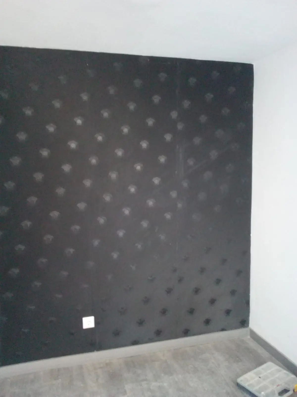 Pared revestida con papel pintado negro de dibujo geométrico
