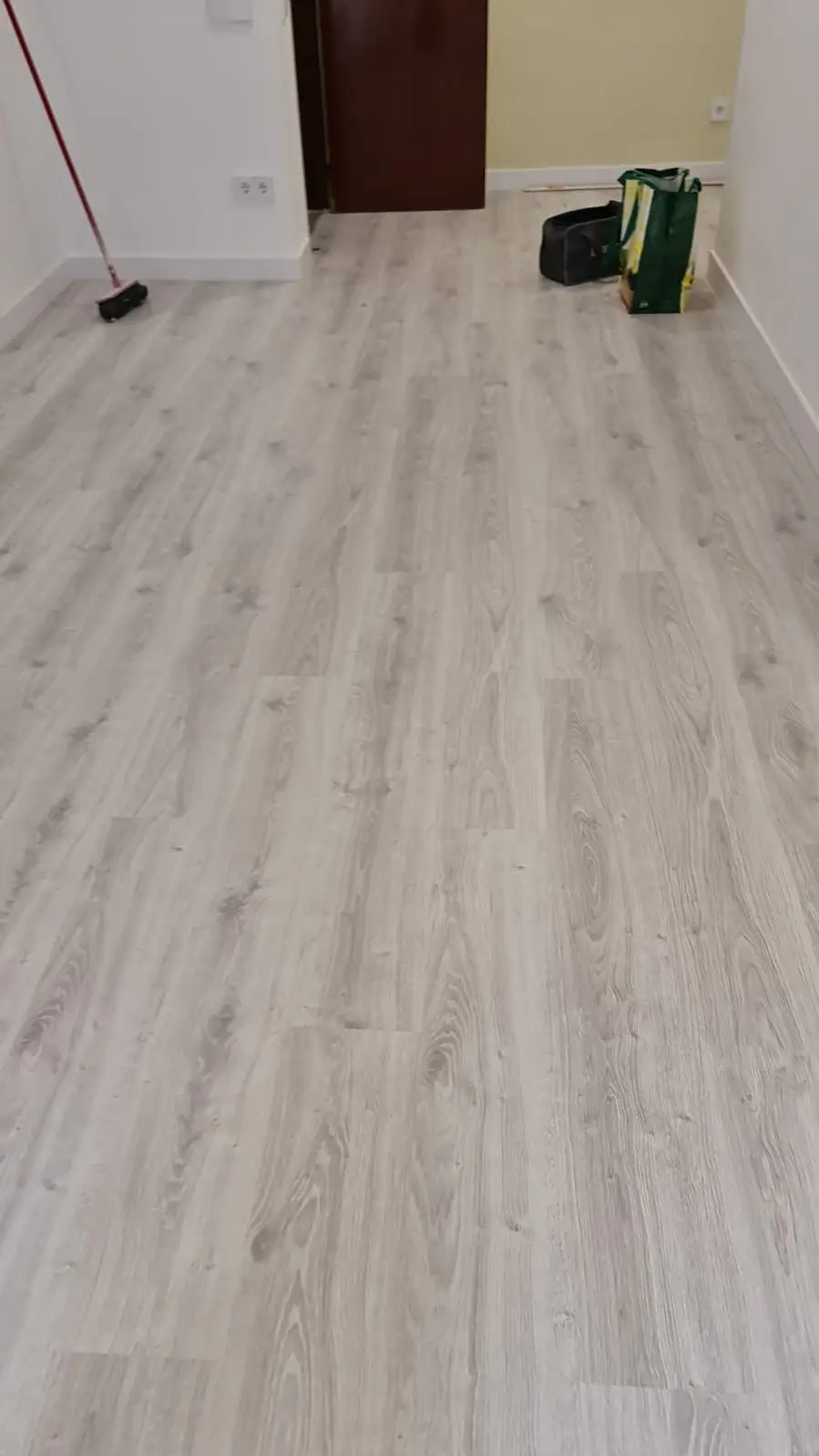Estancia con suelo laminado gris claro recién colocado